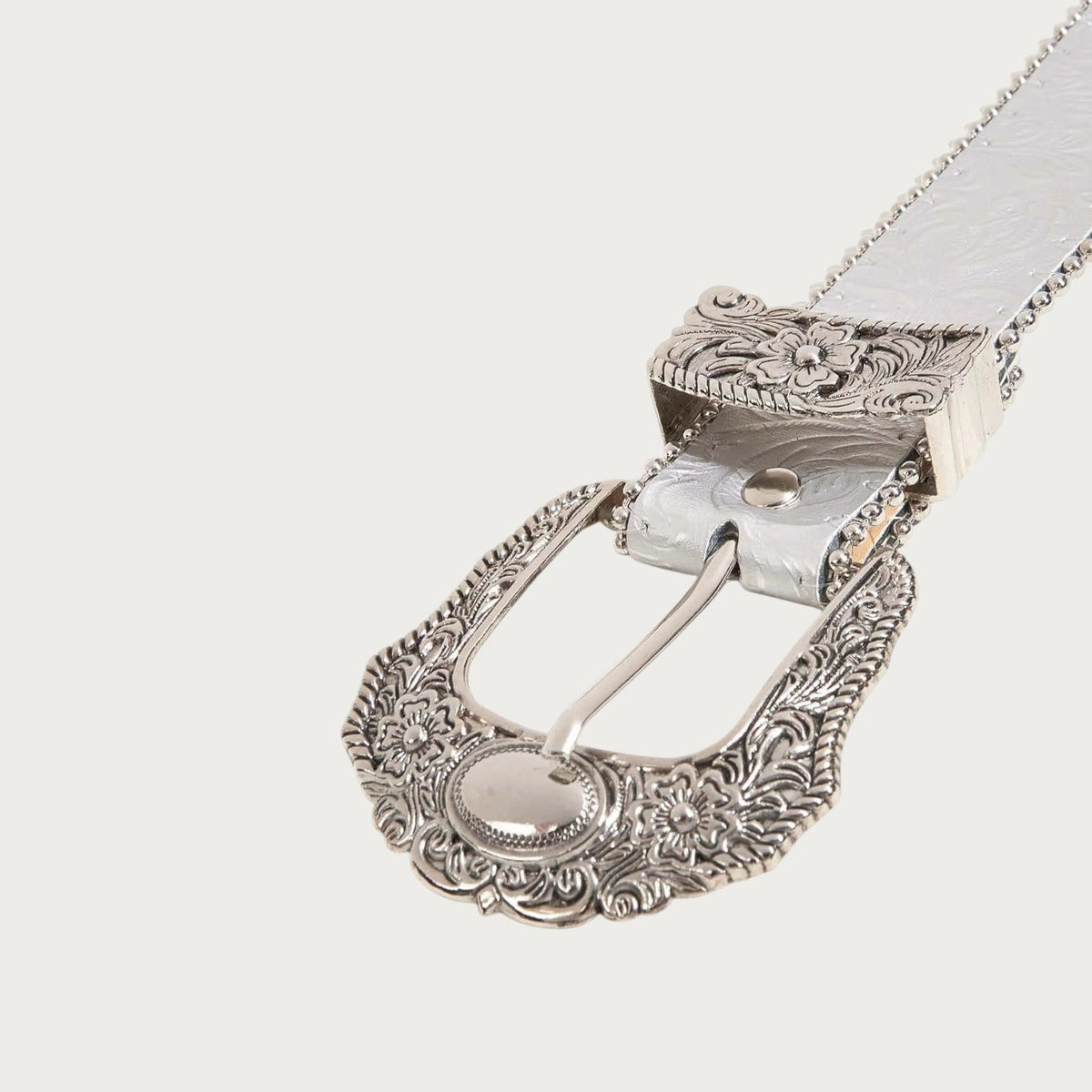 Gros plan sur la boucle western ciselée de la ceinture Ceintura Silvia argentée