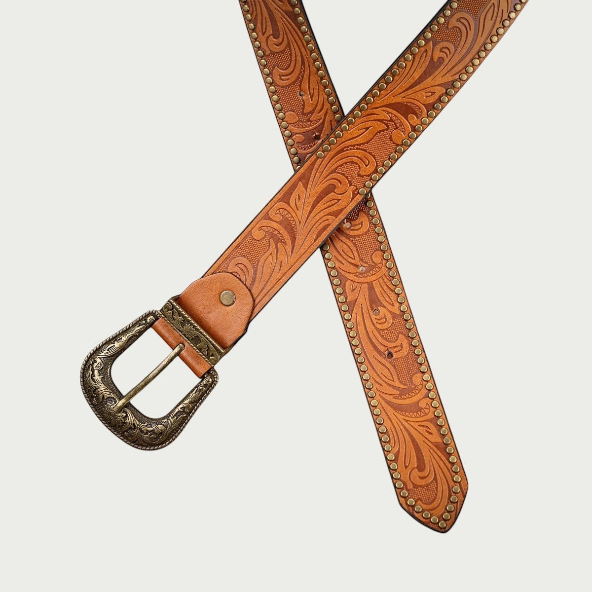 Ceinture Ceintura Concordia cognac croisée, gaufrage floral en relief et clous dorés sur les bords