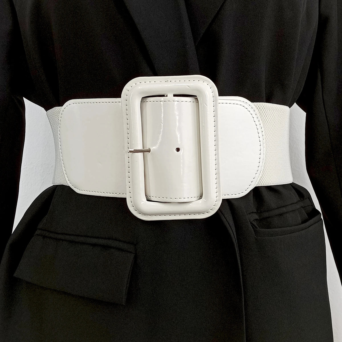 Ceinture élastique blanche Ceintura Bari avec large boucle rectangulaire vernie portée sur un blazer noir