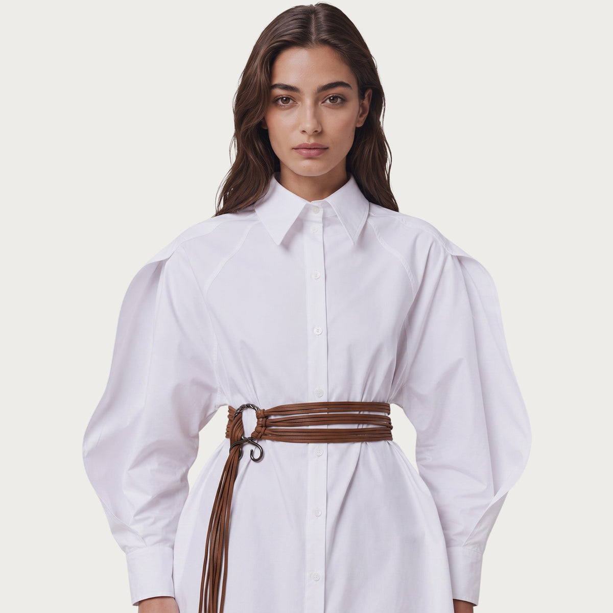Ceinture bohème Ceintura Delicata en lanières brunes souples avec anneau métallique sur une chemise blanche