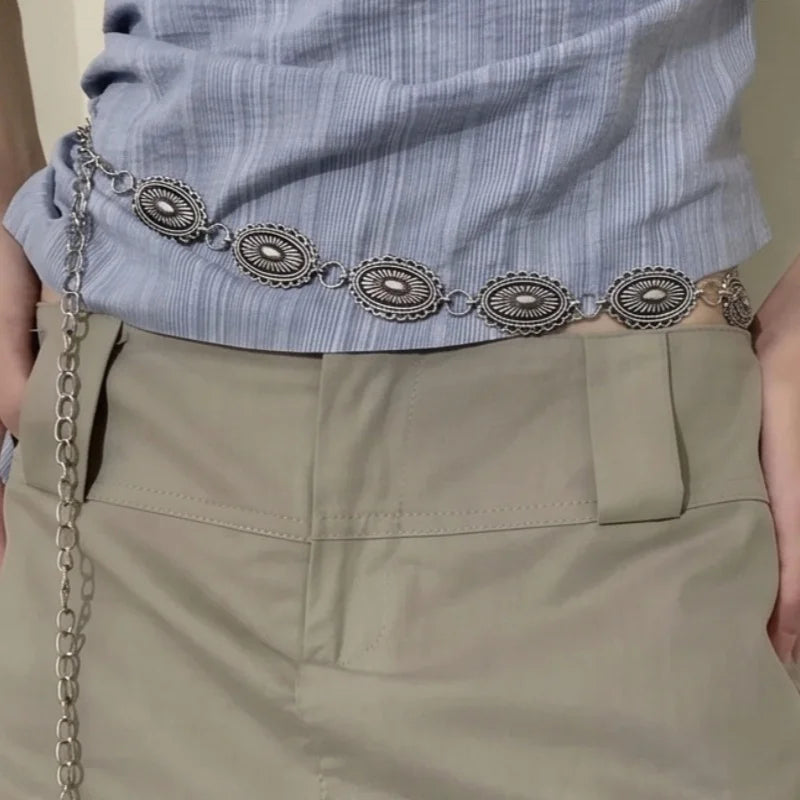 Ceinture chaine Ceintura argentée style vintage avec médaillons gravés portée sur une jupe beige