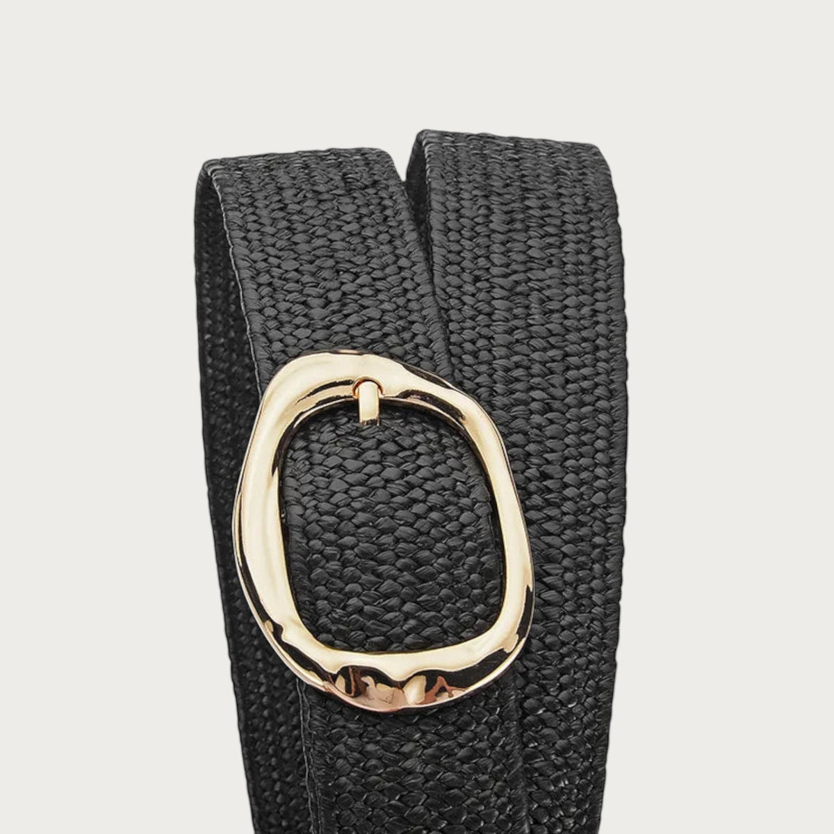 Gros plan sur la boucle ovale dorée martelée de la ceinture Ceintura Stella en corde tressée noire