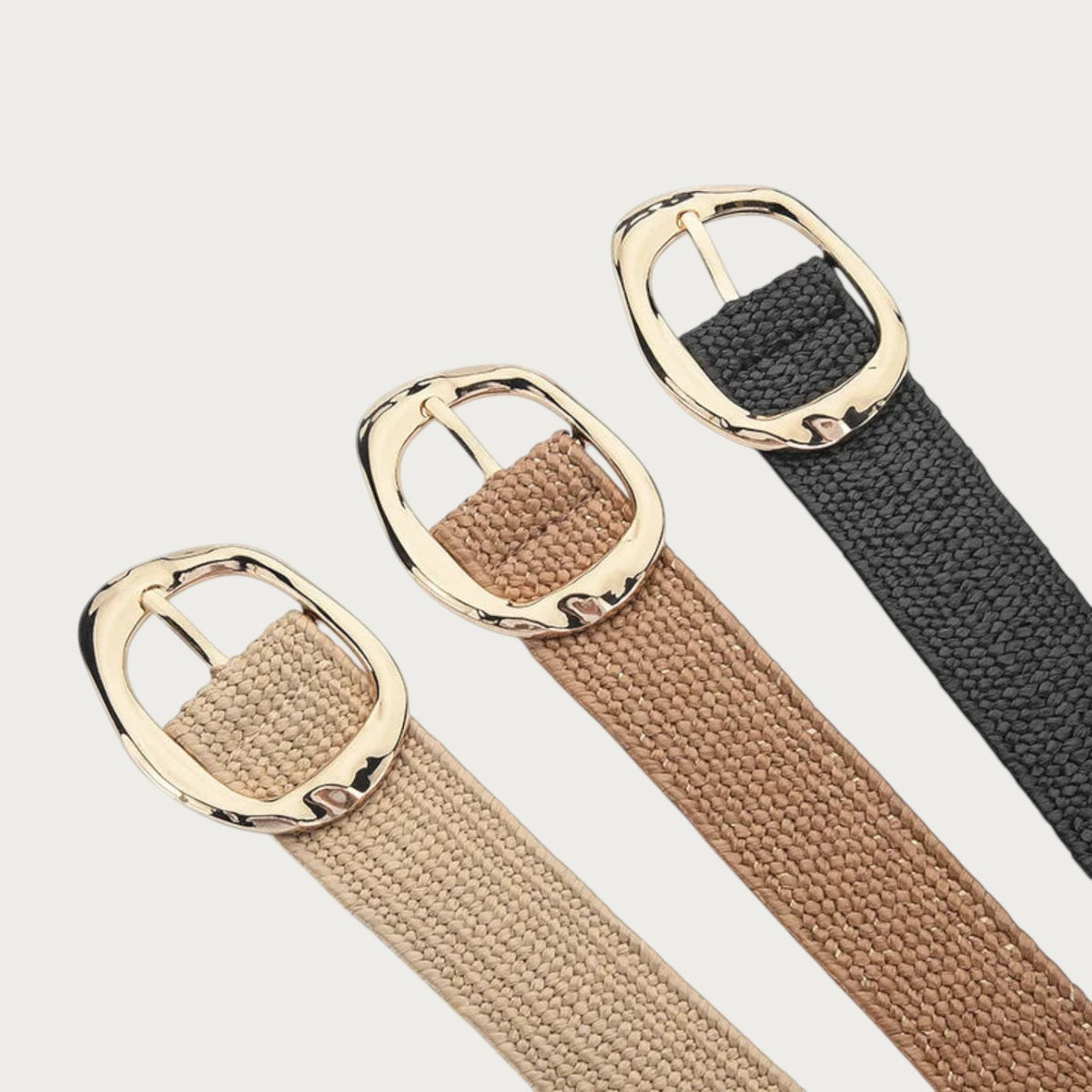 Ceintures Ceintura Stella en corde tressée avec boucle ovale dorée martelée, disponibles en beige, camel et noir.