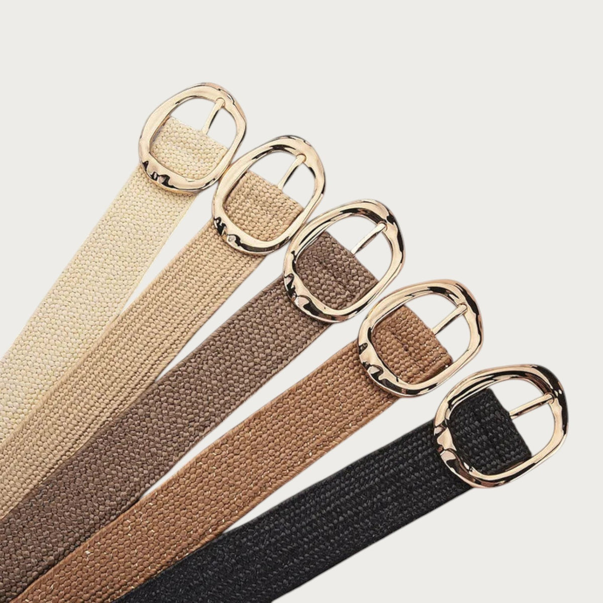 Ceinture Ceintura Stella en corde tressée avec boucle ovale dorée martelée, disponible en cinq coloris naturels.