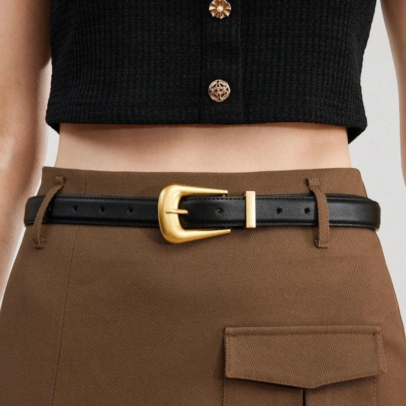 Ceinture Ceintura Sienne en cuir noir lisse avec une boucle dorée sculptée au style western moderne portée sur une jupe