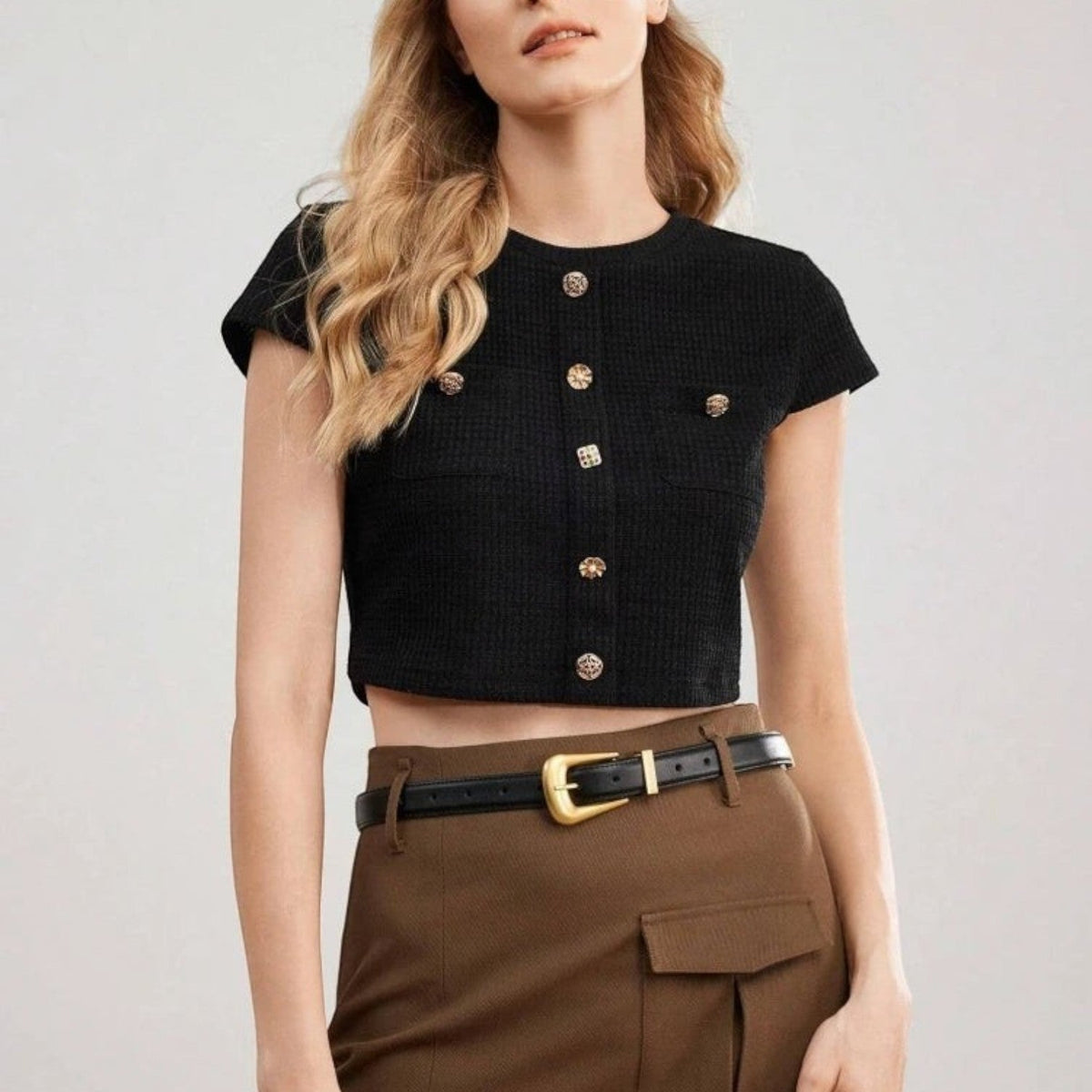 Ceinture en cuir noir Ceintura avec boucle dorée sculptée portée par une femme sur une jupe marron
