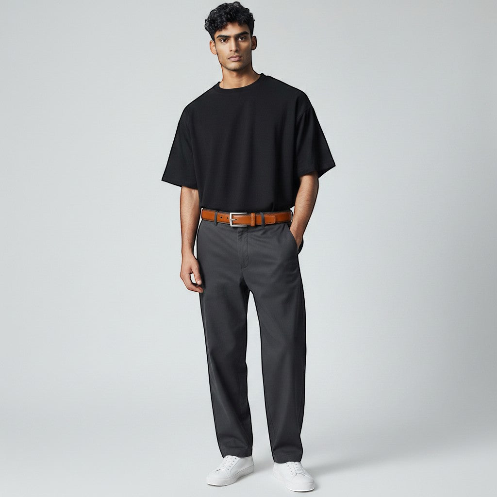 Homme portant une ceinture en cuir marron Ceintura avec un t-shirt noir et un pantalon gris décontracté