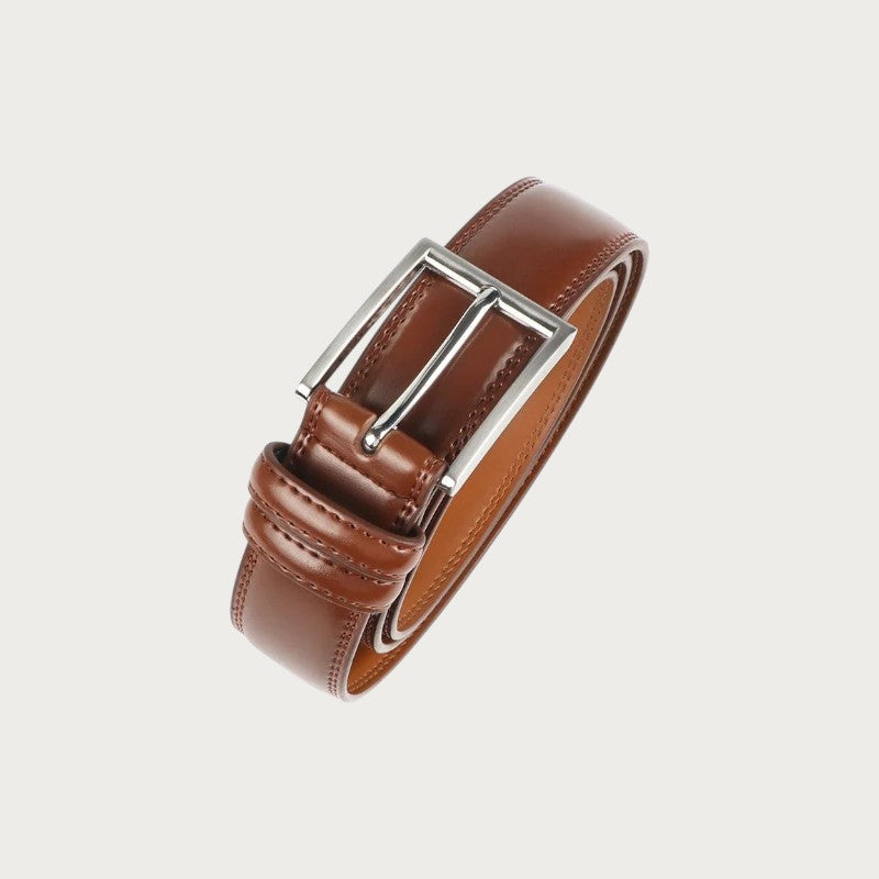 Ceinture Ceintura Brindisi en cuir marron enroulée, gros plan sur la boucle ardillon argentée et le passant