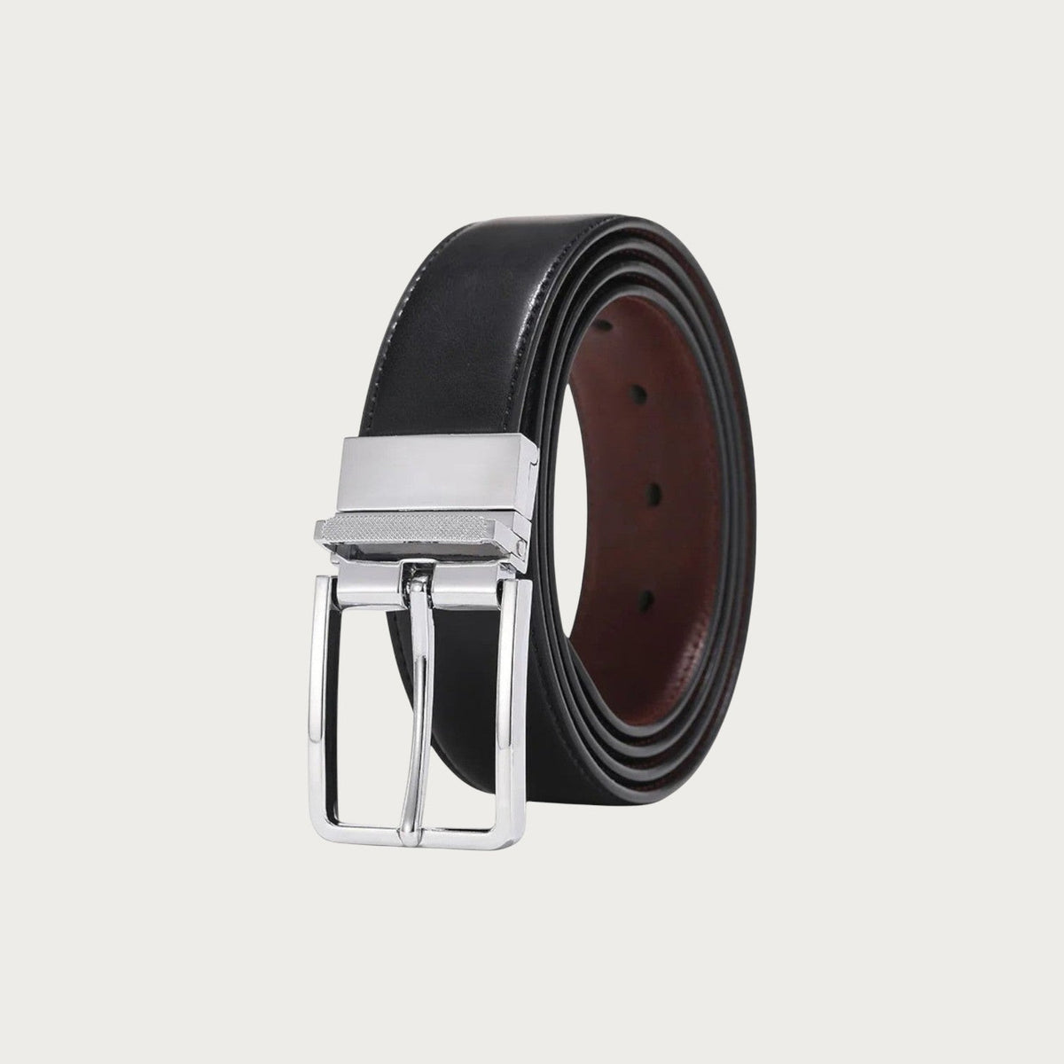 Ceinture réversible Ceintura enroulée montrant sa face noire et sa face bordeaux, boucle rotative chromée