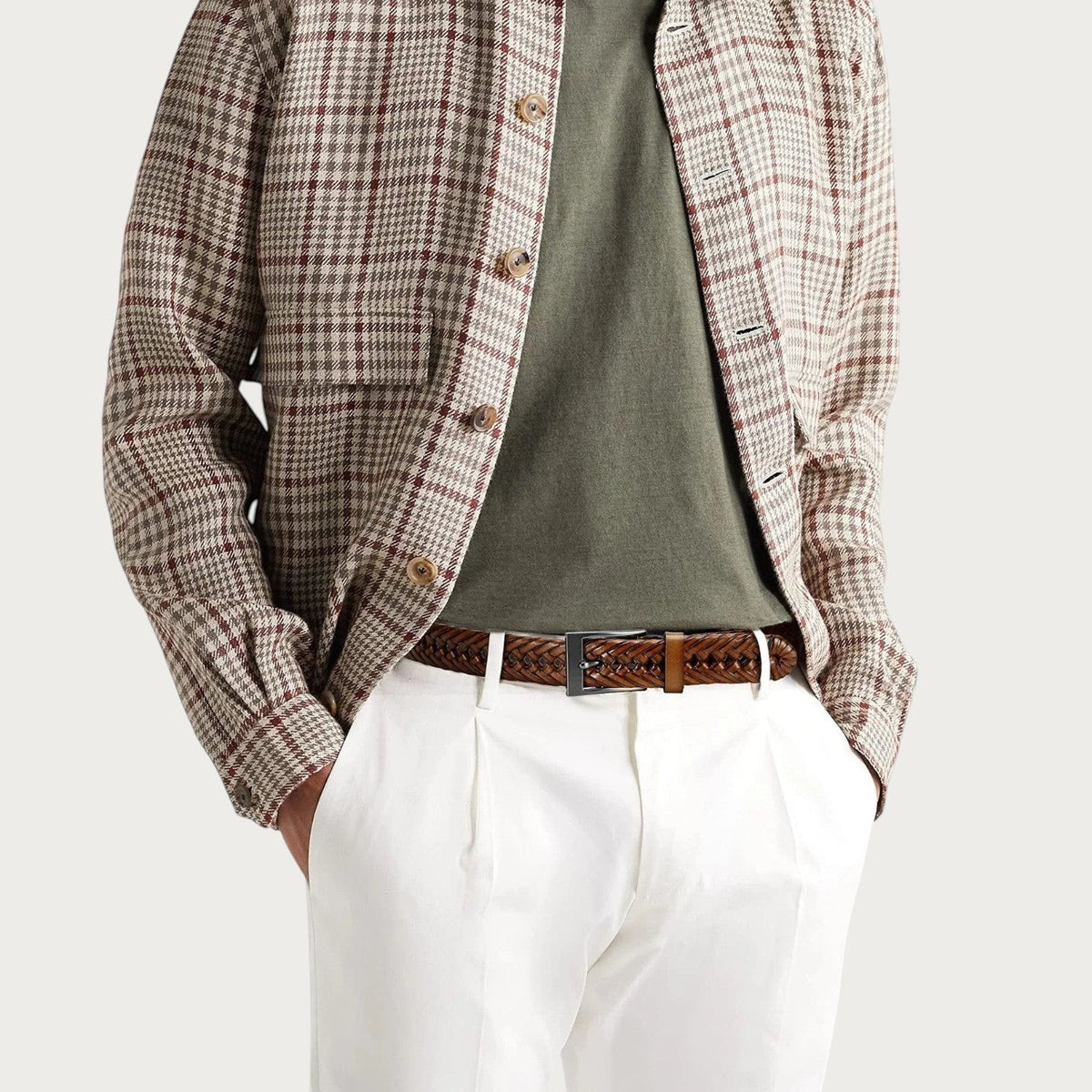 Homme en veste à carreaux et pantalon blanc portant la ceinture Ceintura Federico en cuir tressé marron