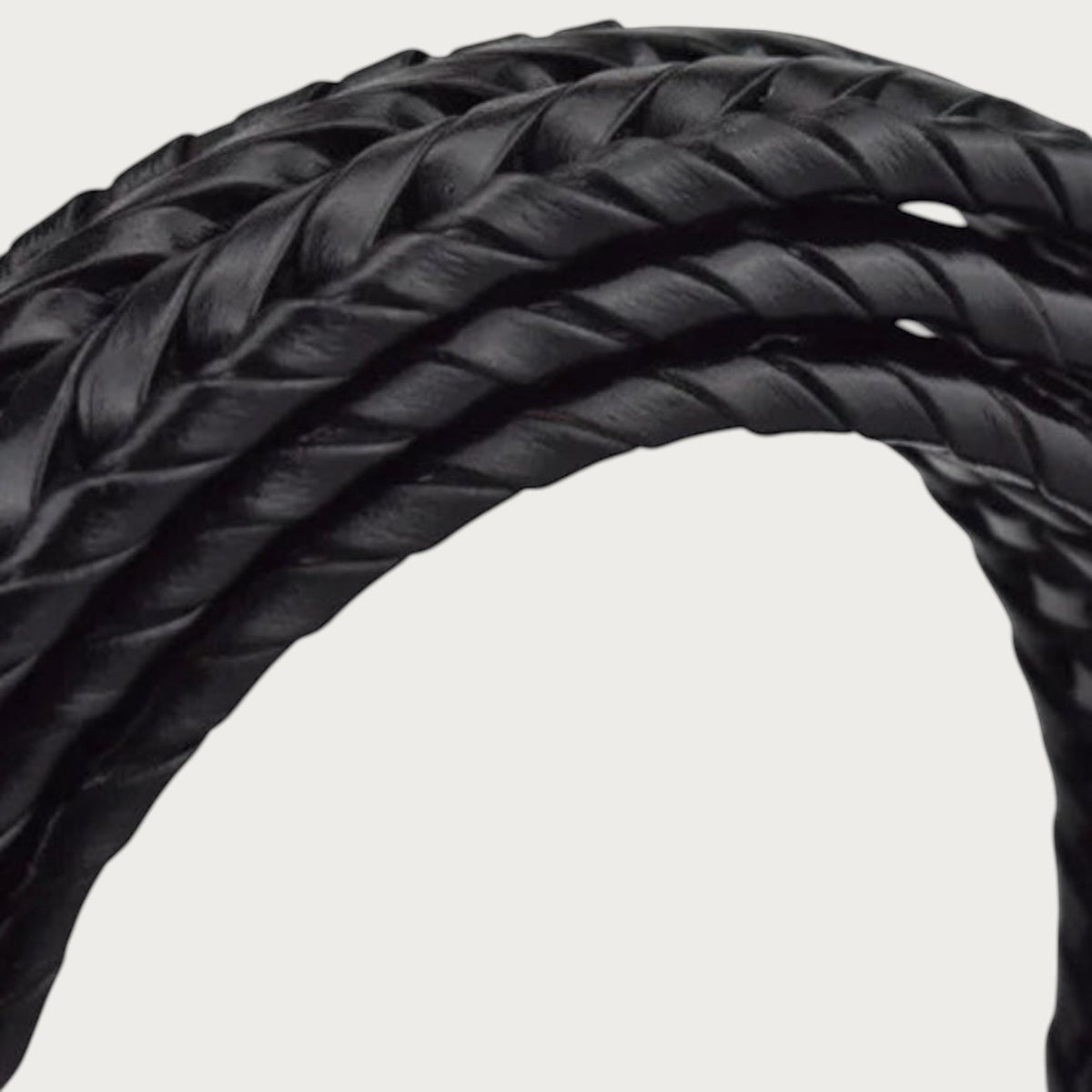 Gros plan sur la ceinture Ceintura Armonia en cuir de vachette noir avec un tressage torsadé artisanal en relief.