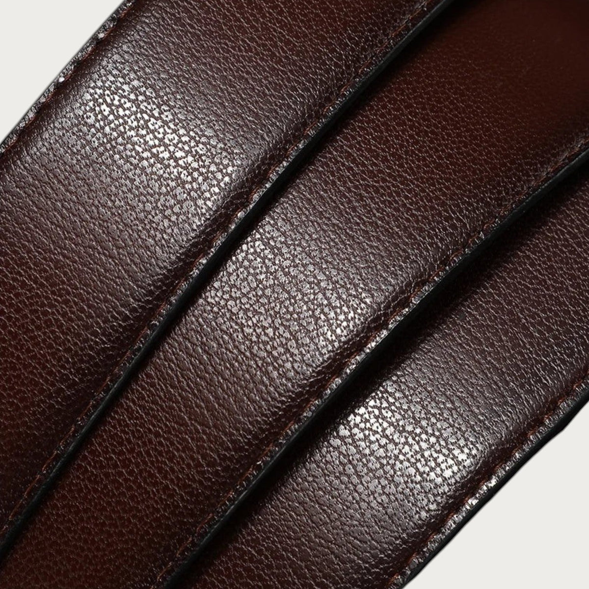 Gros plan sur la texture en cuir de vachette marron de la ceinture réversible Ceintura Dante pour homme