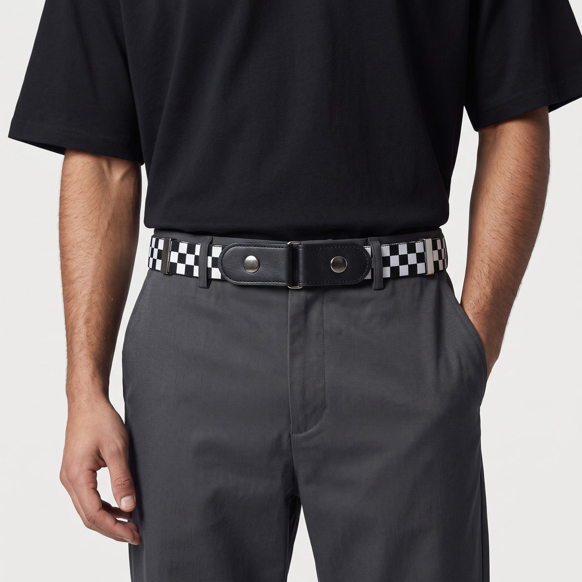 Ceinture sans boucle Ceintura élastique à motif damier noir et blanc avec pattes en similicuir sur un pantalon gris