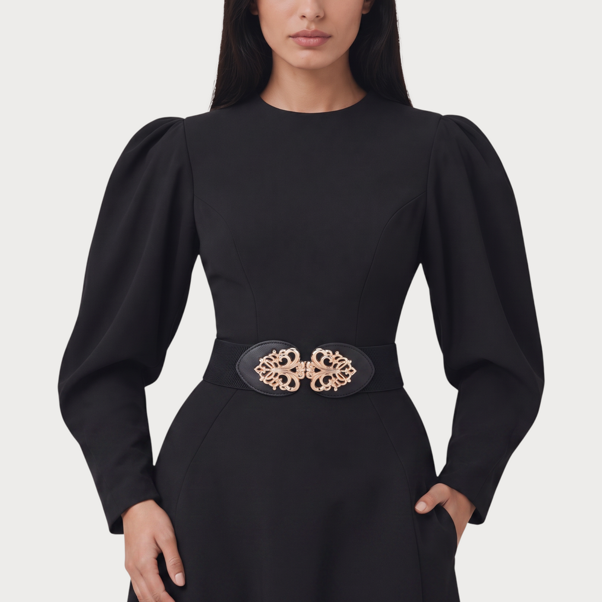 Ceinture élastique noire Ceintura avec boucle dorée ajourée en motif floral portée sur une robe noire Image
