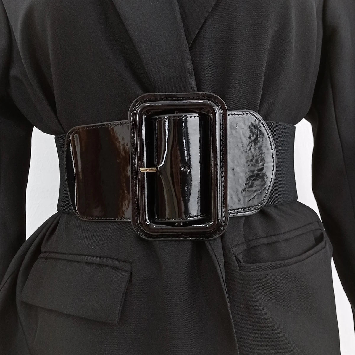 Ceinture Ceintura Bari noire élastique large avec une grande boucle rectangulaire vernie portée sur un blazer noir