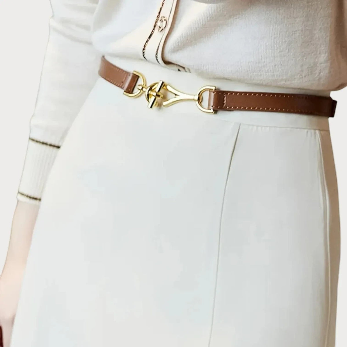 Ceinture fine en cuir marron Ceintura avec boucle mors dorée élégante portée sur une jupe blanche