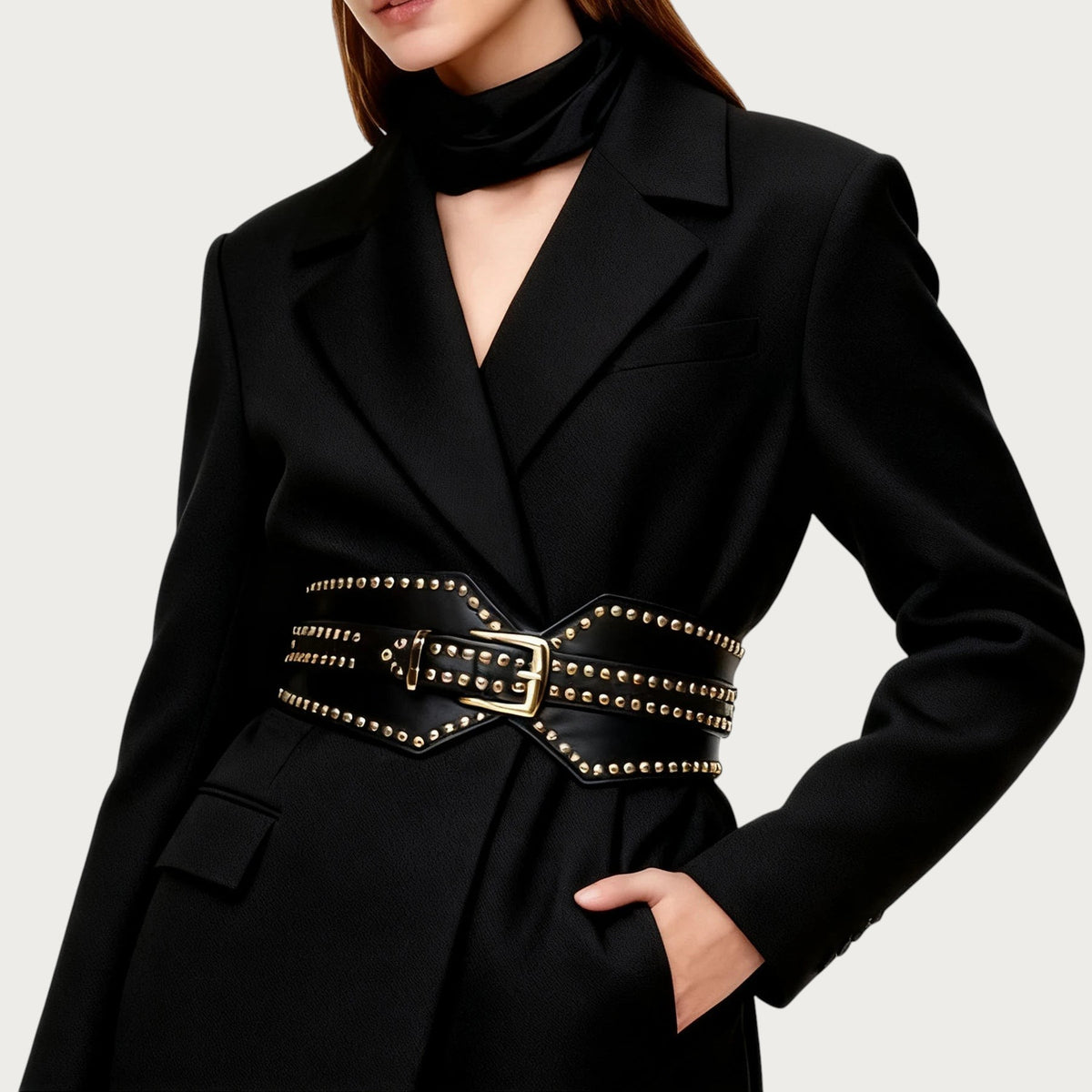 Ceinture large Ceintura en similicuir noir pour femme avec clous dorés décoratifs portée sur un blazer noir
