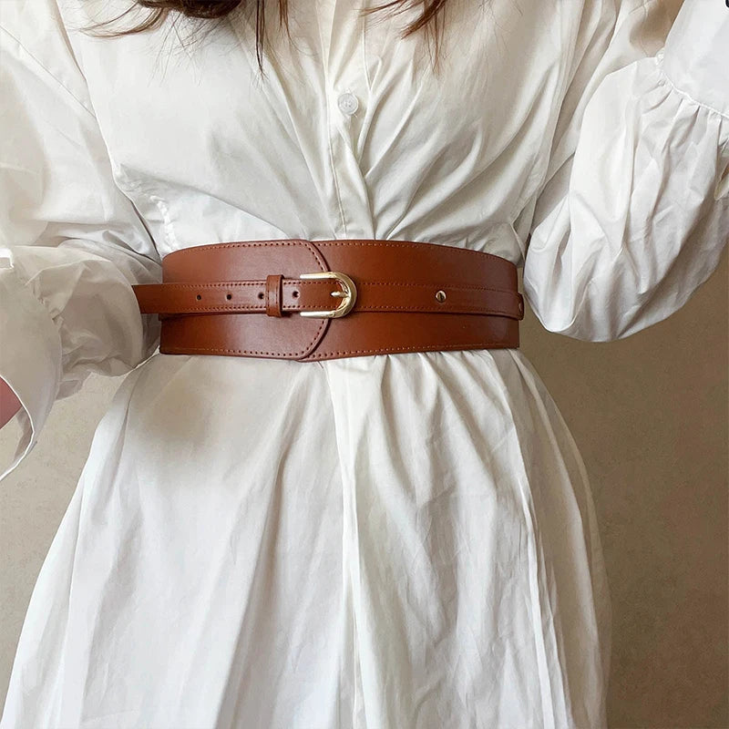 Ceinture large taille haute Ceintura en similicuir cognac style corset avec boucle dorée sur une chemise blanche