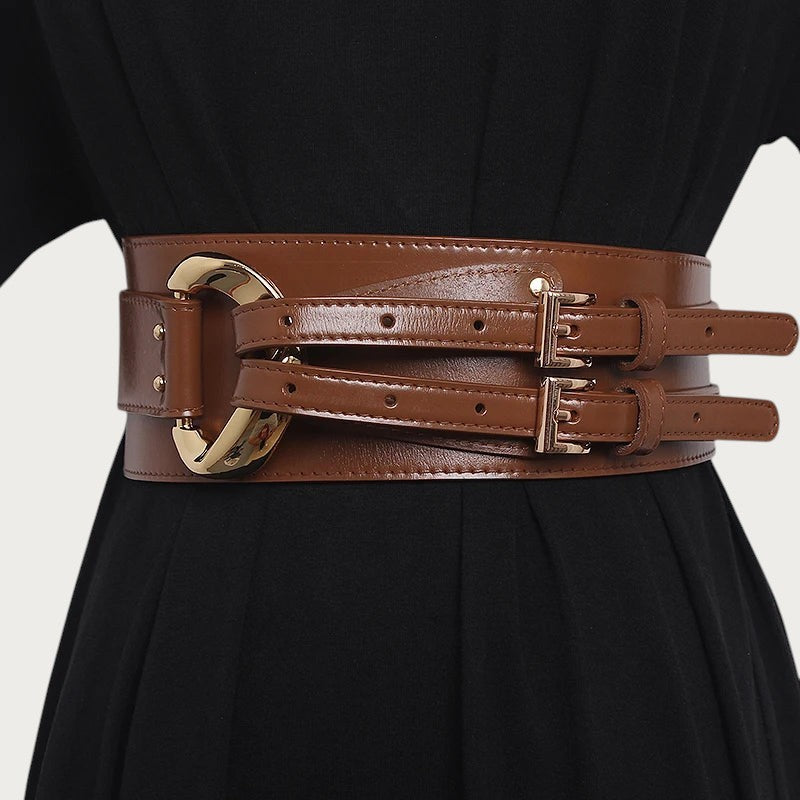 Ceintura large ceinture obi marron en cuir de vachette avec boucles métalliques dorées sur une robe noire