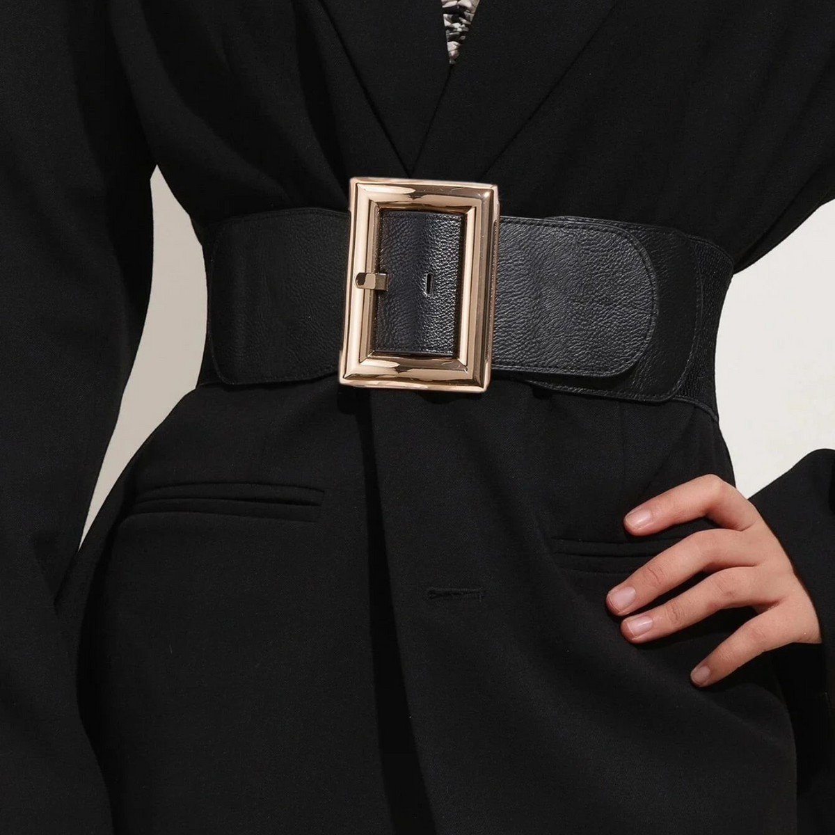 Ceinture large Ceintura Ferrare en similicuir noir avec boucle rectangulaire dorée portée sur un blazer noir