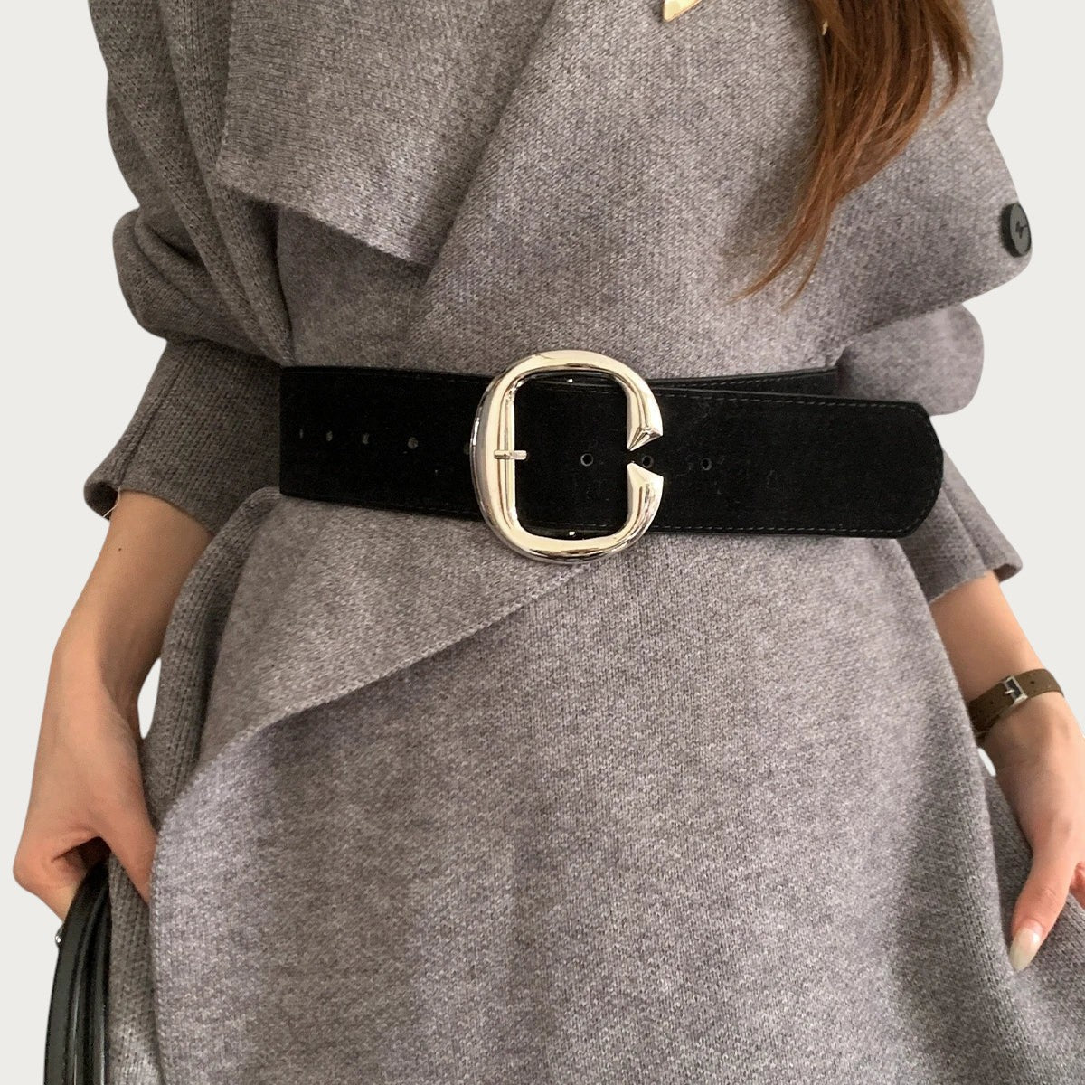 Ceintura ceinture large noire effet velours avec boucle métallique argentée portée sur un manteau gris
