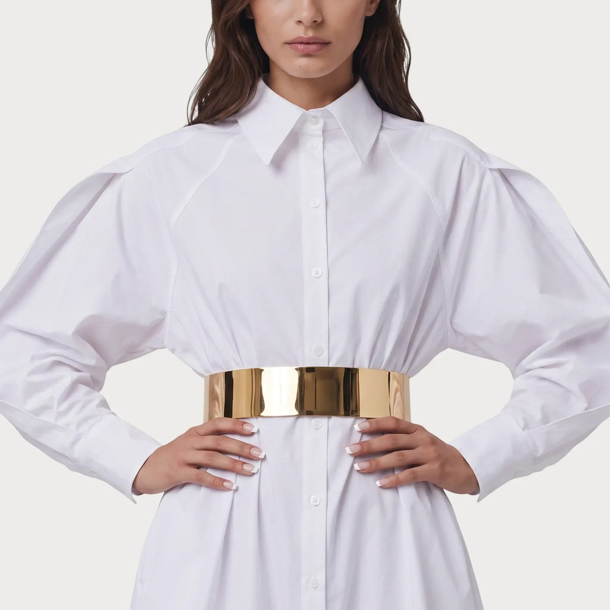 Ceinture bijou Ceintura dorée en métal rigide portée sur une chemise blanche pour un style élégant et moderne