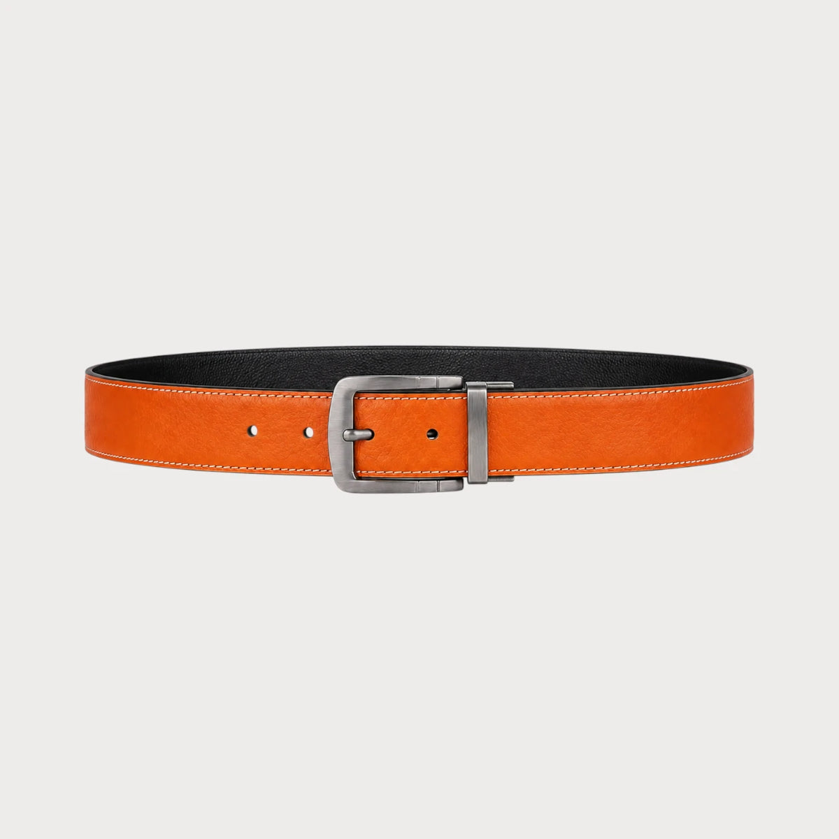 Ceinture réversible Ceintura Ugo en similicuir orange et noir déployée à plat, boucle pivotante argentée