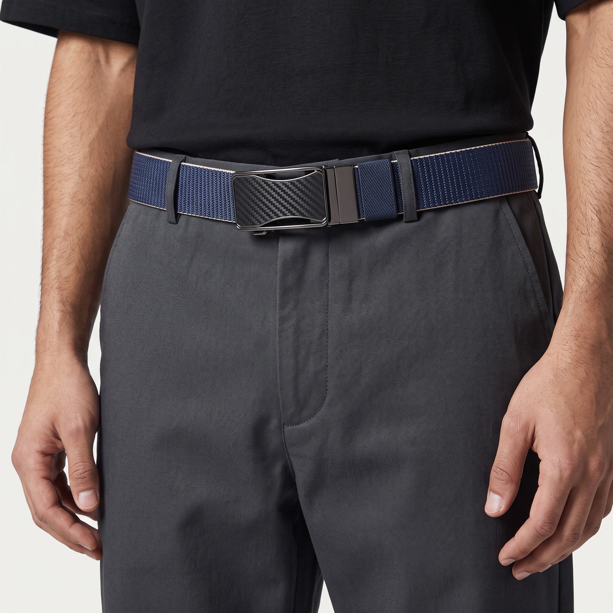 Ceinture réversible Ceintura Ettore en toile bleue avec boucle plaque noire mate portée sur un pantalon gris Image
