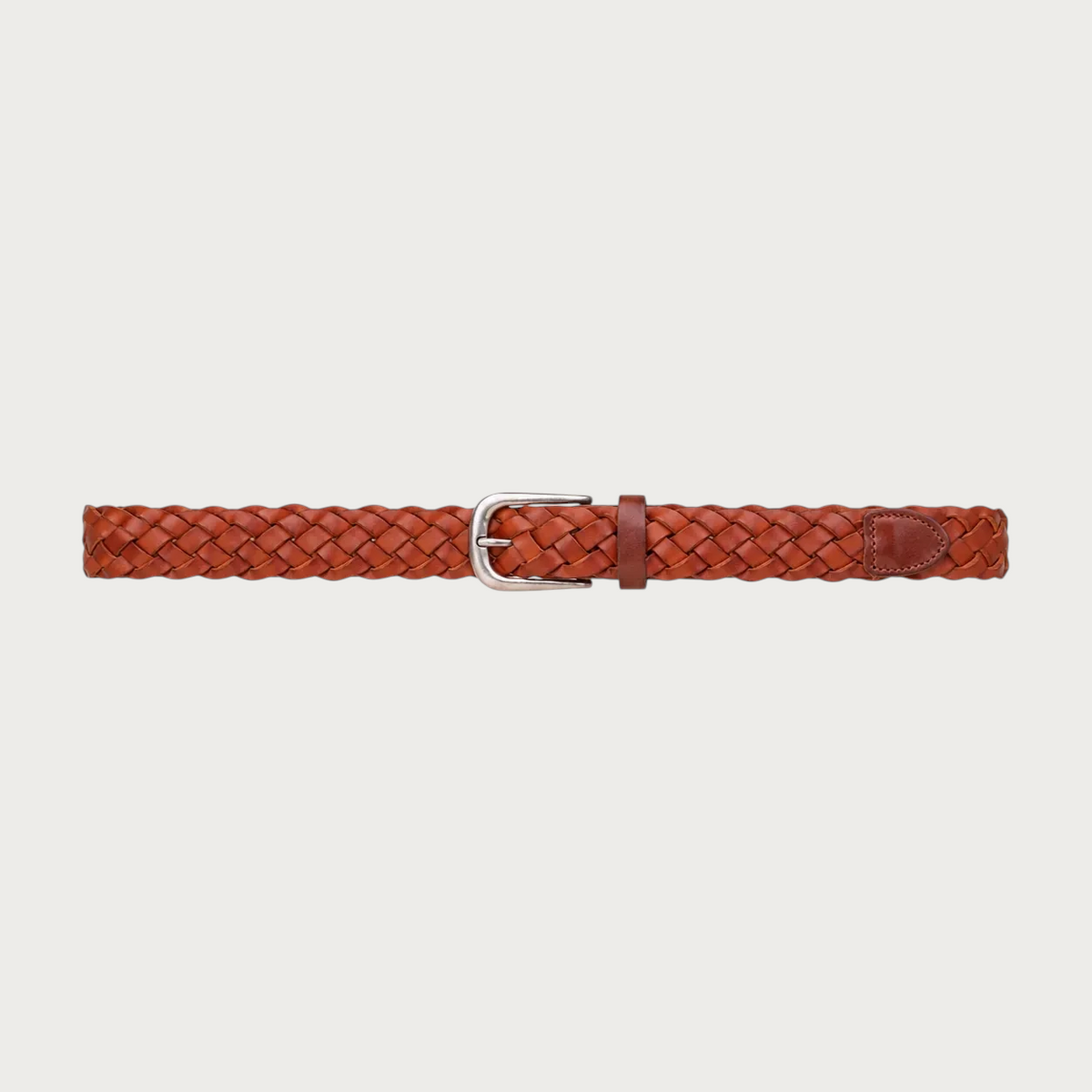 Ceinture tressée Ceintura en cuir cognac déployée à plat, petite boucle argentée arrondie au centre